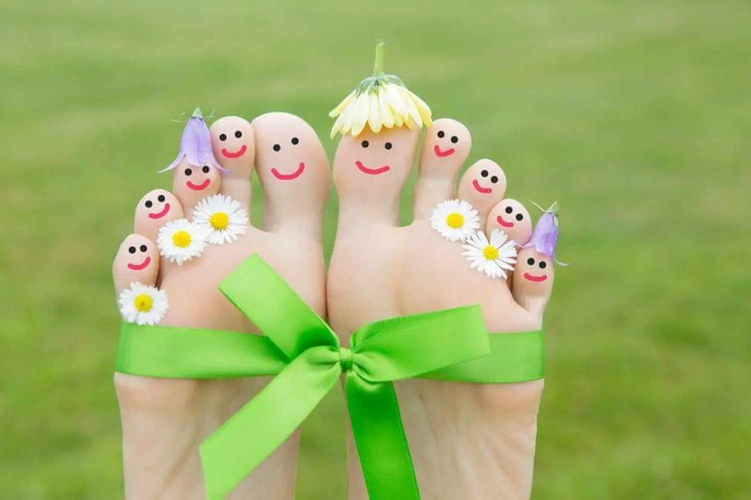 Füße mit Band mit Smileys und Blumen an den Zehen gebunden